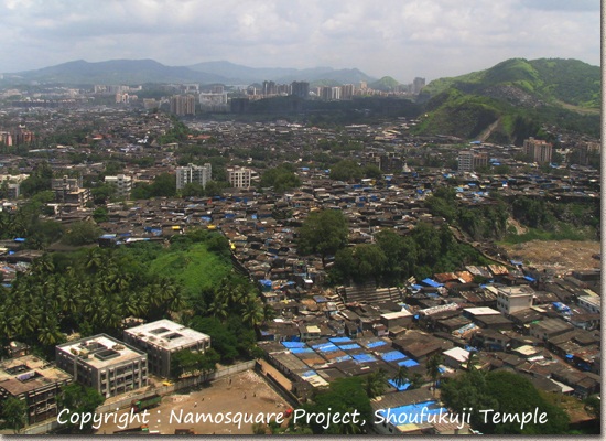 ムンバイ空港近くの町並み。山腹まで家が建ち並び、向こうには高層マンションが見える。
